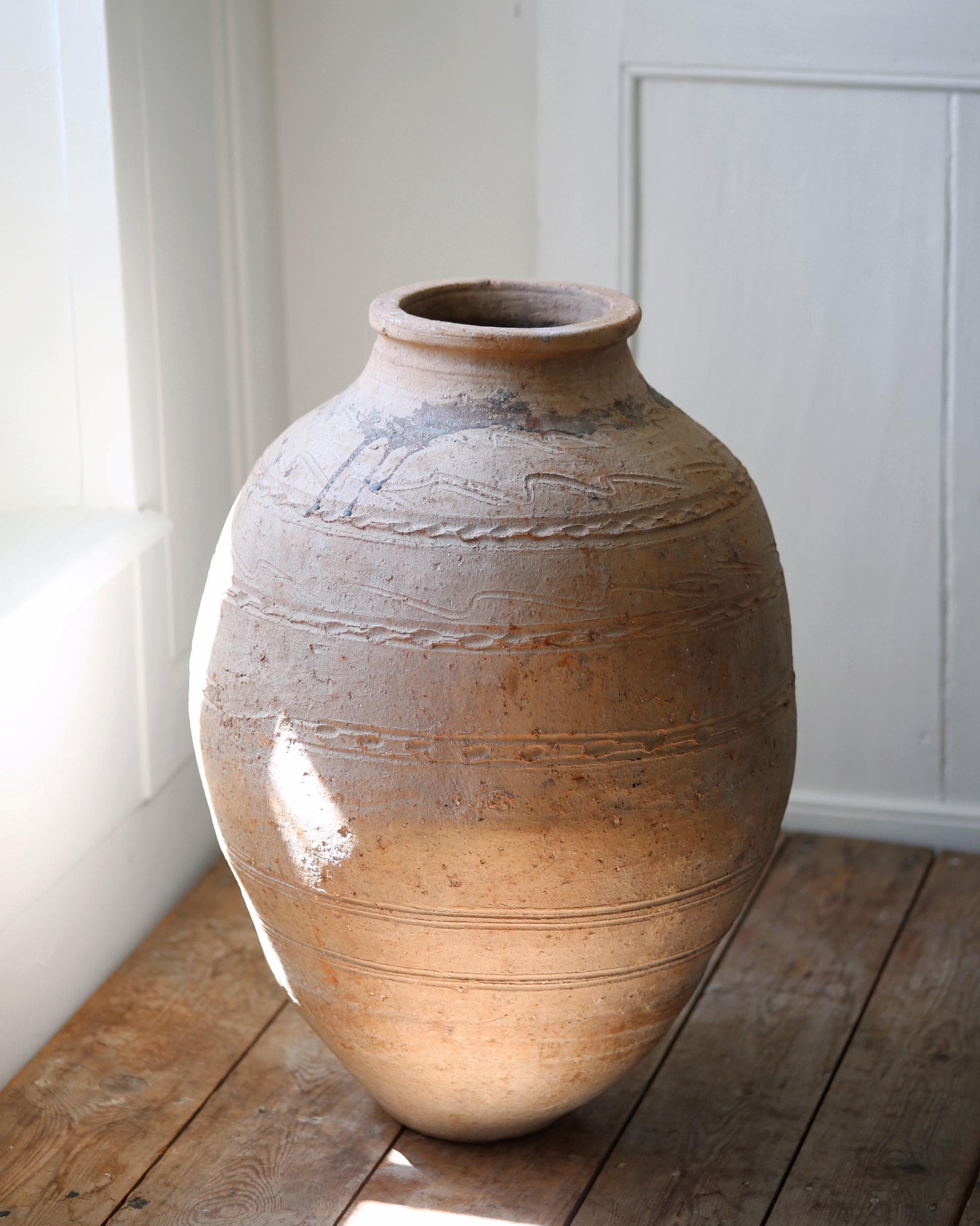 Large terracotta olive pot showing narrow opening