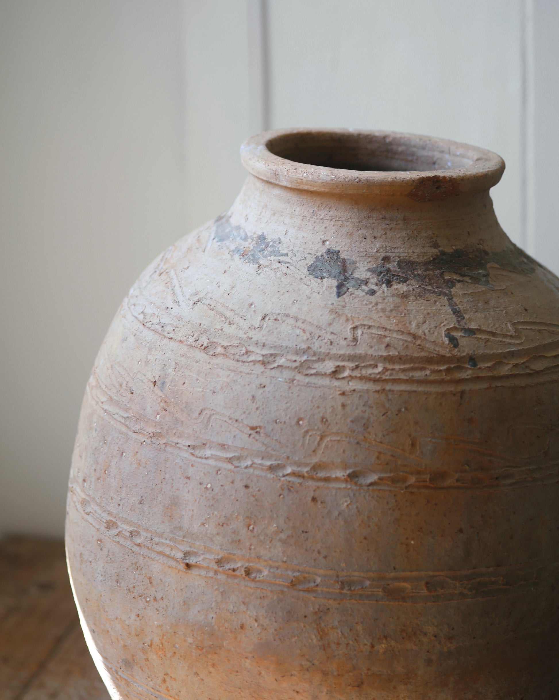 Close up of sand coloured large floor pot with hand finished detailing and naturally aged markings