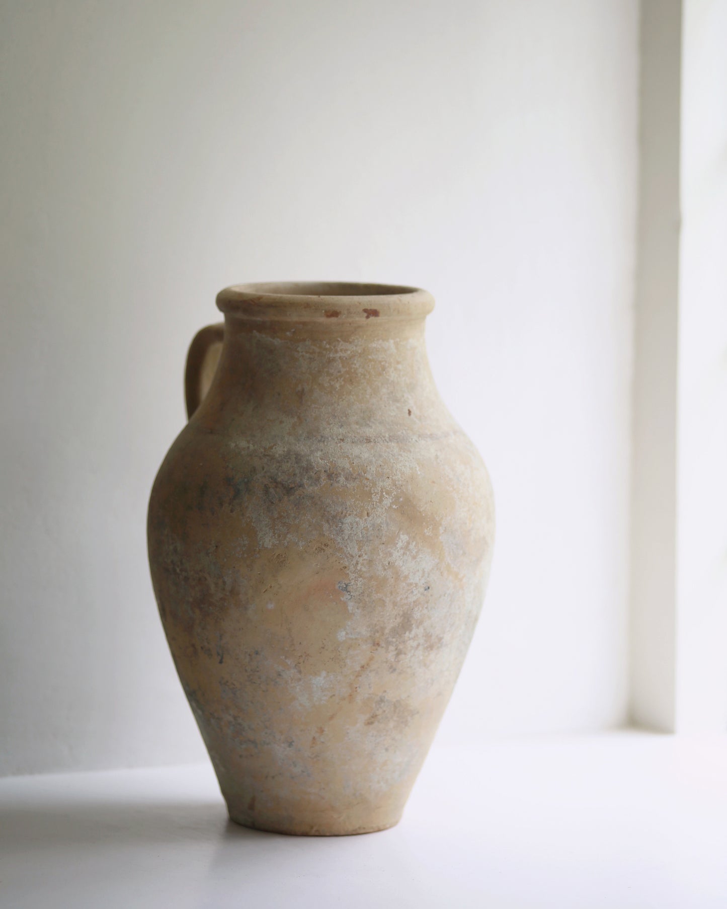 Large statement antique pottery displayed in sunny window sill