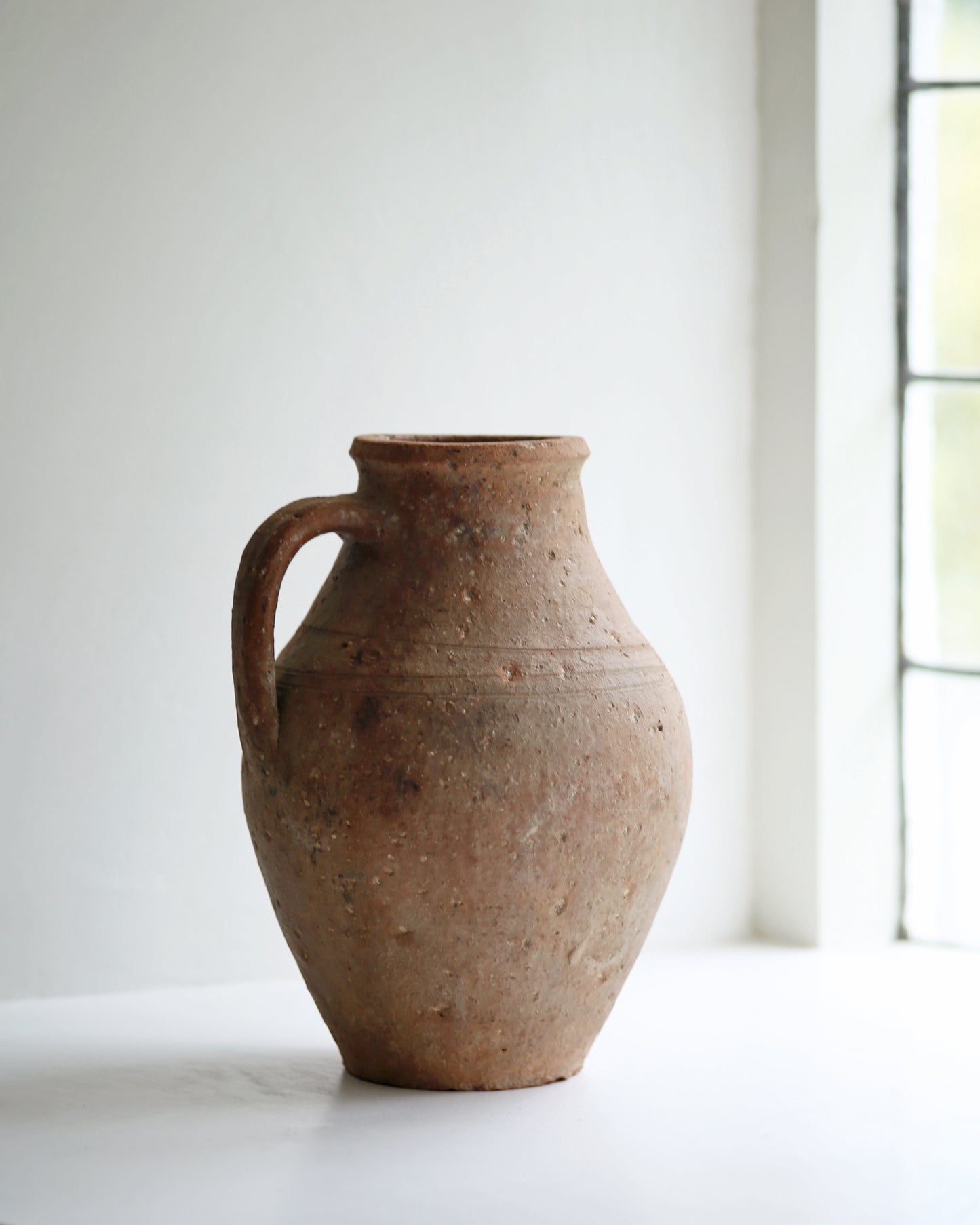 Antique olive pot displayed as decorative piece in farmhouse window sill