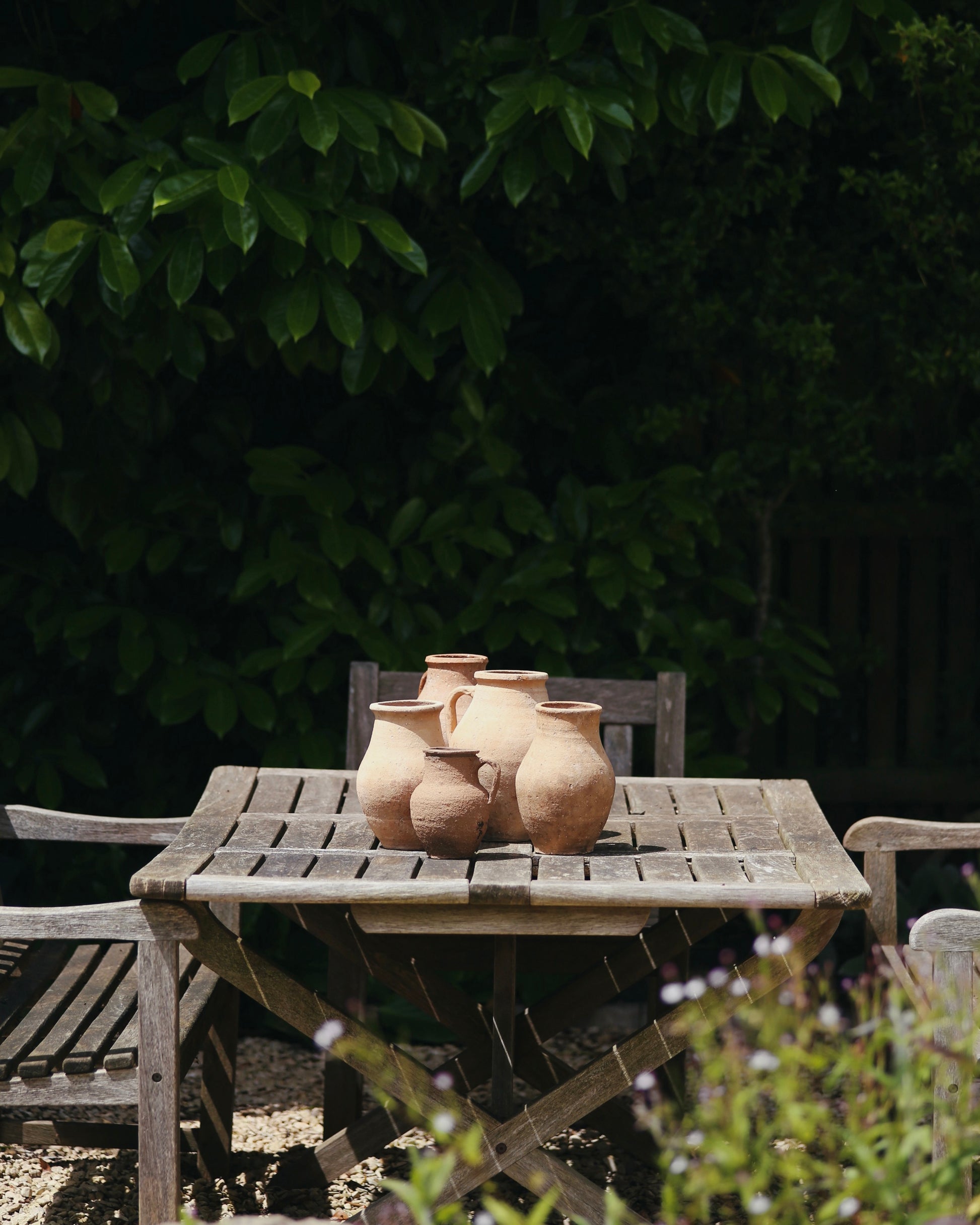 Collection of antique Turkish terracotta pots in mediterranean inspired English country garden