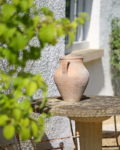 Aged terracotta pottery as outdoor garden table centrepiece