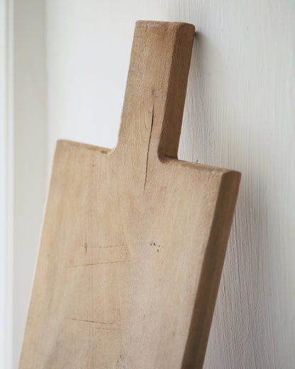 Primitive wooden bread board displayed in kitchen window sill