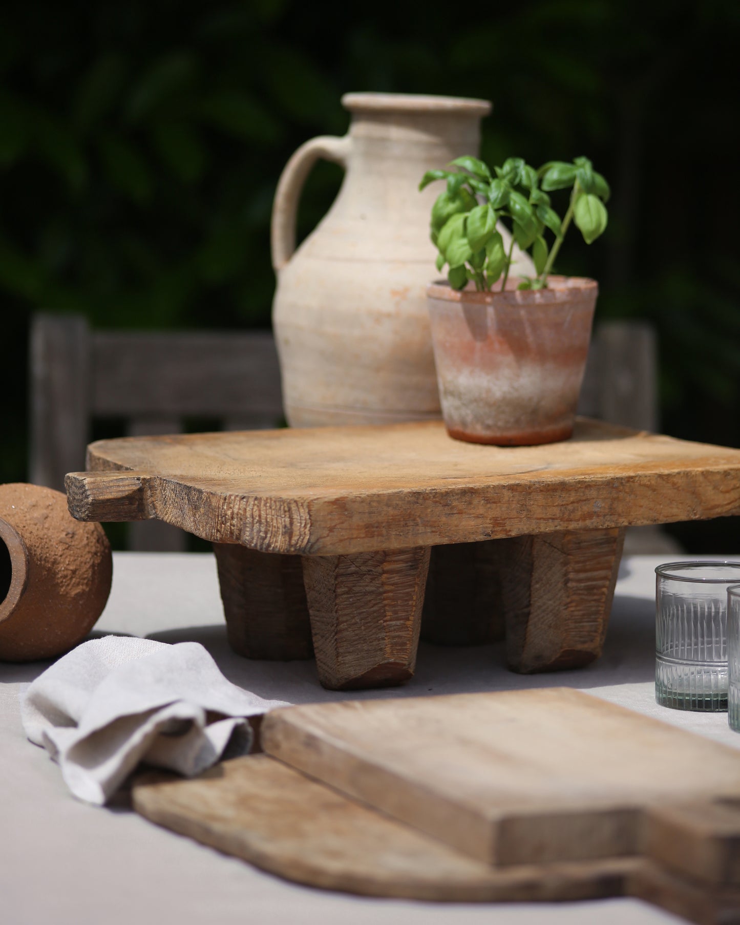 Raised wooden serving board for food display shown al fresco dining setting