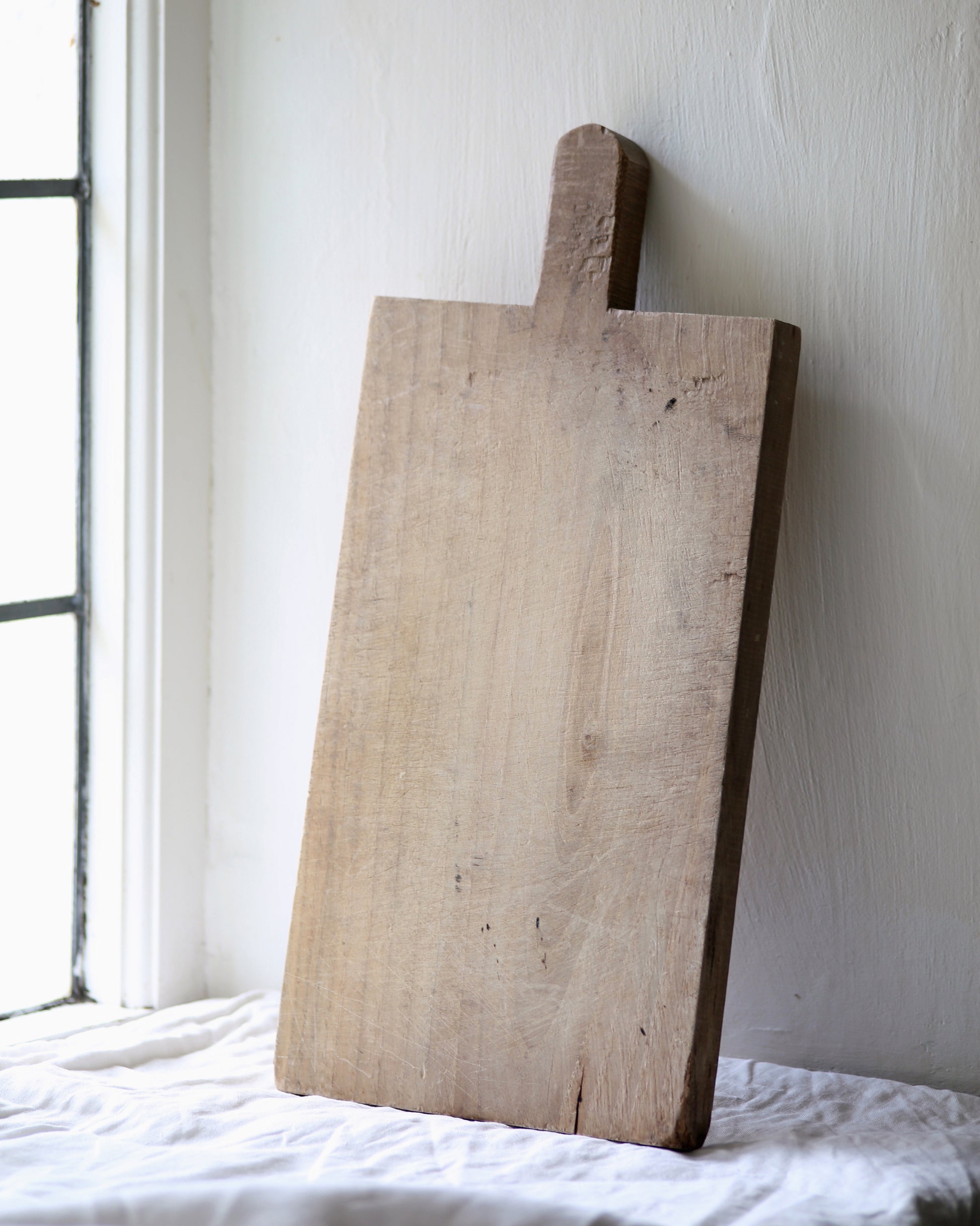 Unique vintage bread board displayed in kitchen window sill