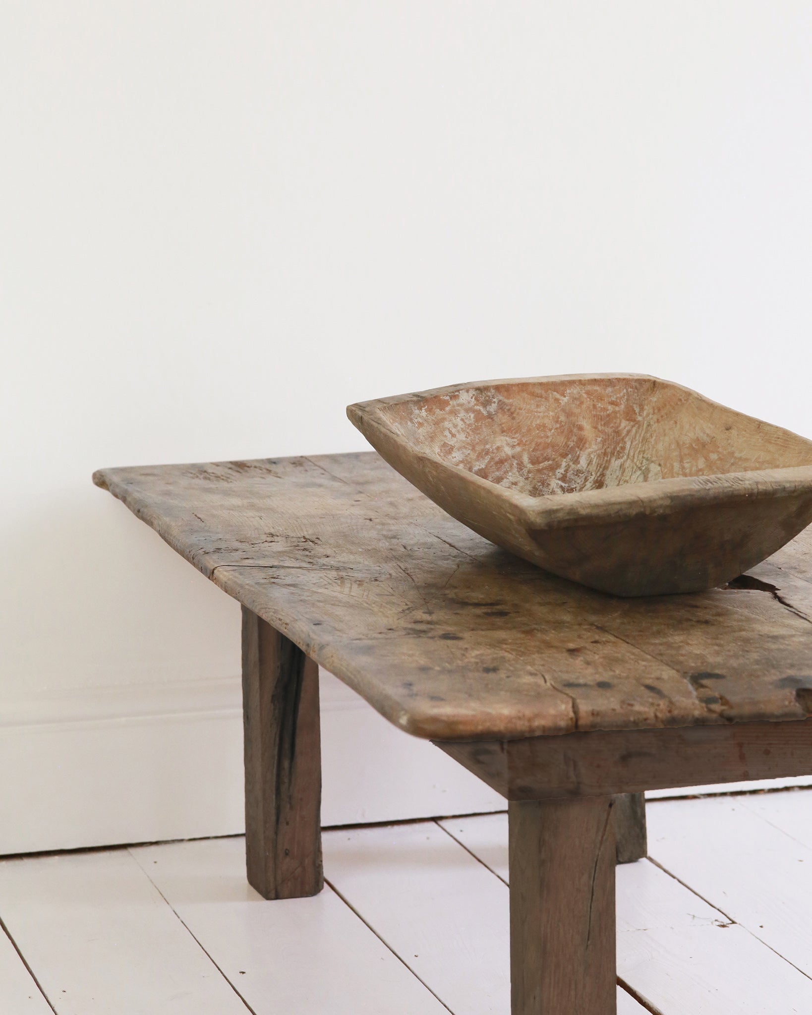 Rustic wooden dough bowl styled on coffee table